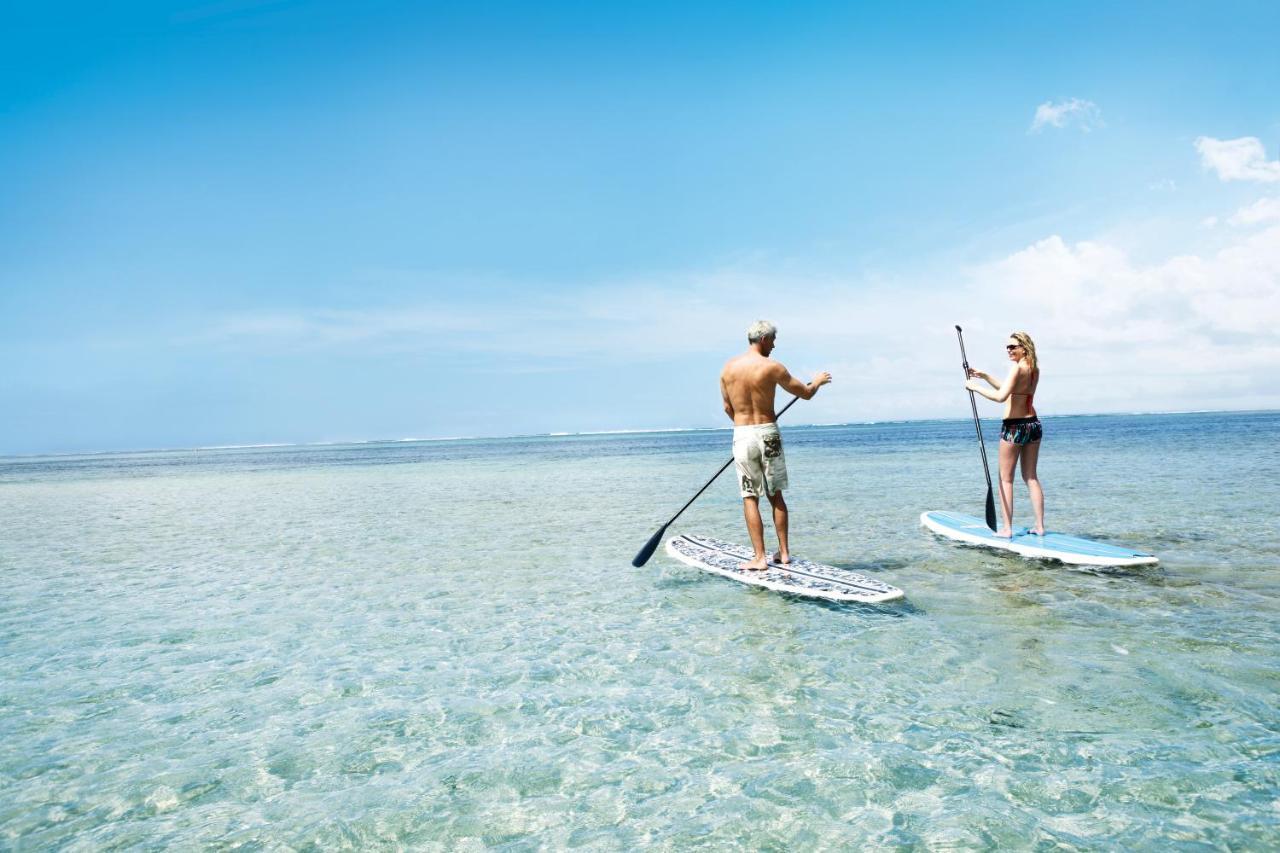Heritage Le Telfair Golf & Wellness Resort Bel Ombre Kültér fotó Stand-up paddle boarders on a lagoon